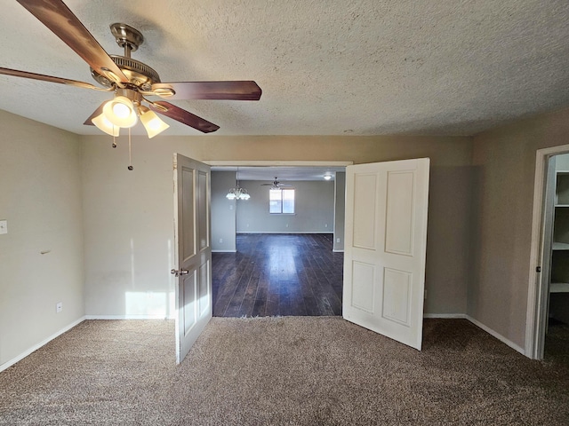 empty room featuring carpet flooring, a ceiling fan, baseboards, and a textured ceiling