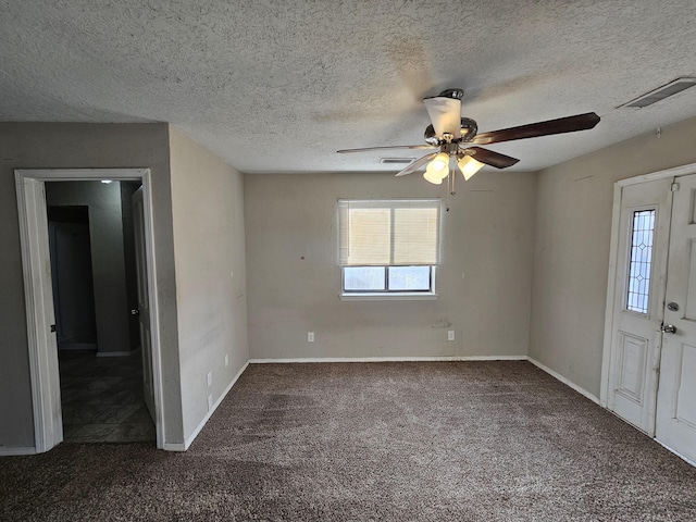 interior space with a textured ceiling, baseboards, visible vents, and ceiling fan