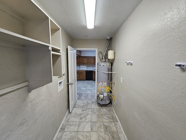 hall featuring baseboards, a textured wall, water heater, and a textured ceiling