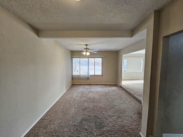 carpeted empty room with baseboards, a textured ceiling, and a ceiling fan