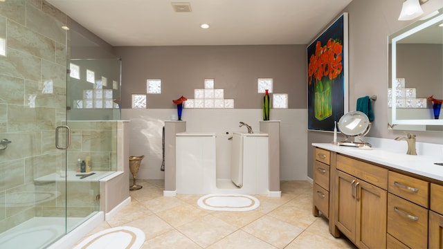 full bathroom featuring vanity, tile patterned flooring, a shower stall, and visible vents