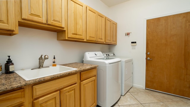 laundry area with cabinet space, light tile patterned floors, a sink, and independent washer and dryer