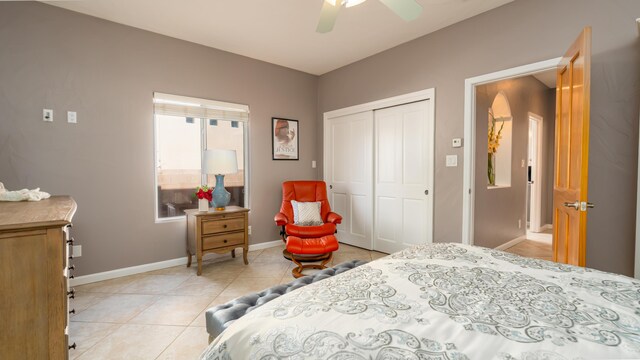 bedroom featuring ceiling fan, a closet, light tile patterned flooring, and baseboards