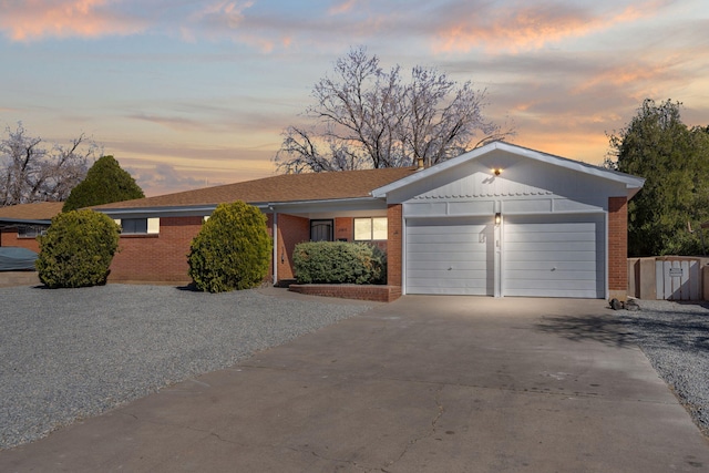 ranch-style home featuring brick siding, an attached garage, and driveway