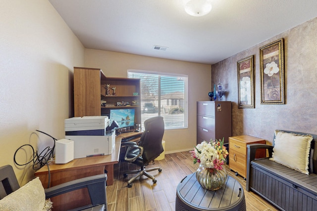 office with light wood-type flooring, baseboards, and visible vents