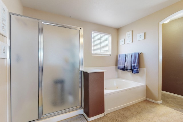 full bathroom with a stall shower, a garden tub, and baseboards