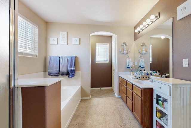 bathroom featuring a sink, double vanity, baseboards, and a bath