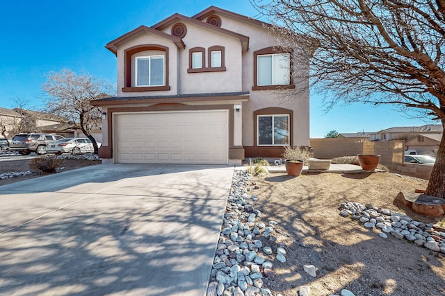 view of front of house featuring a garage, concrete driveway, fence, and stucco siding