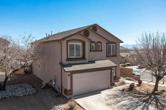 view of front of house with a garage, concrete driveway, a shingled roof, and stucco siding