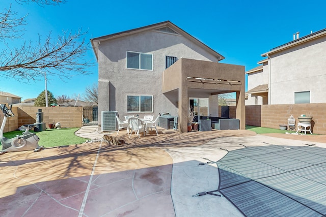 back of house featuring a patio, central AC, a fenced backyard, and stucco siding