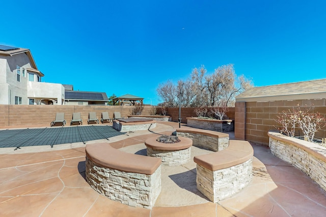 view of patio with an outdoor fire pit and a fenced backyard