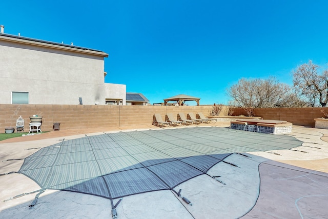 view of swimming pool with a fenced backyard, a fenced in pool, a patio, and a gazebo