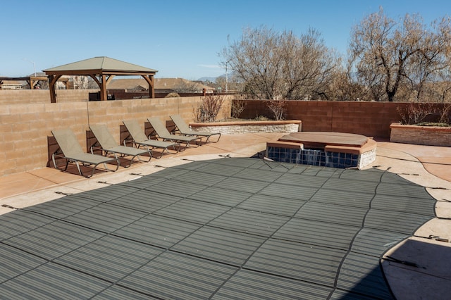 view of swimming pool featuring a patio, a gazebo, a fenced backyard, and a hot tub