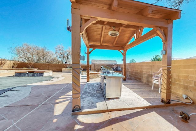 view of patio featuring a fenced backyard, an outdoor kitchen, and a swimming pool