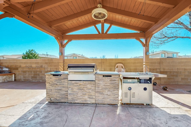 view of patio with fence, grilling area, and a gazebo