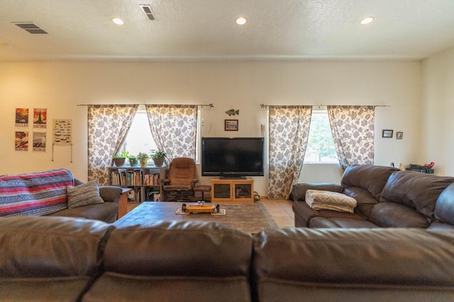 living room with visible vents, a textured ceiling, and recessed lighting