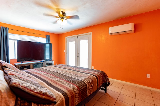 bedroom featuring light tile patterned floors, baseboards, ceiling fan, a wall mounted air conditioner, and french doors