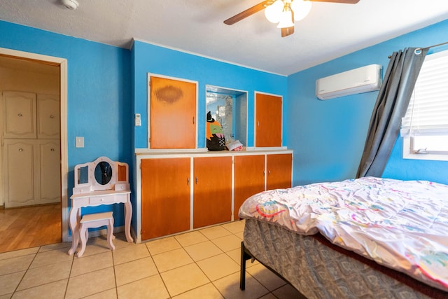 bedroom featuring ceiling fan, a wall mounted air conditioner, and light tile patterned flooring