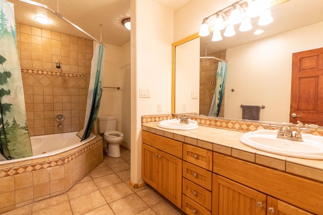 bathroom featuring tiled shower / bath, double vanity, a sink, and tile patterned floors