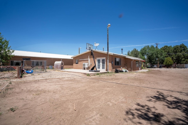 back of house with french doors, fence, a patio, and stucco siding