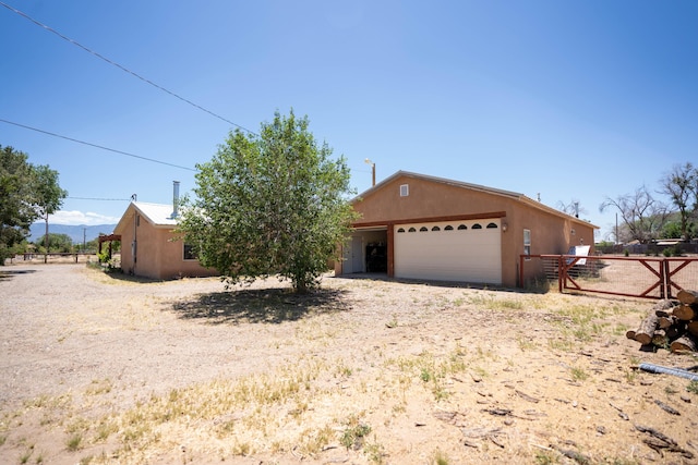 view of front facade with fence, an outdoor structure, and stucco siding