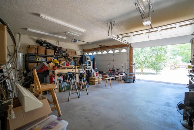 garage with water heater, a workshop area, and a garage door opener