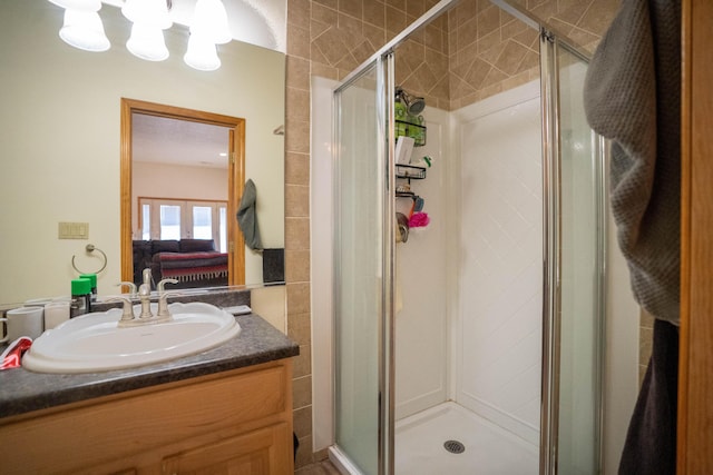 ensuite bathroom featuring a shower stall, vanity, and ensuite bathroom