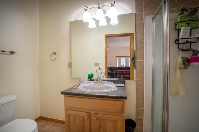 bathroom featuring baseboards, toilet, tile patterned flooring, vanity, and a shower stall