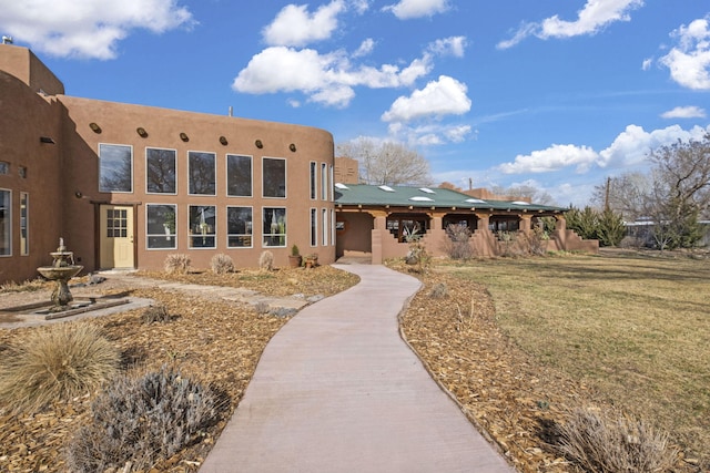 view of front of house with a front lawn and stucco siding