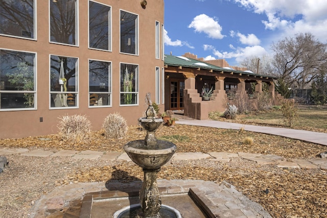 view of front of property featuring metal roof and stucco siding