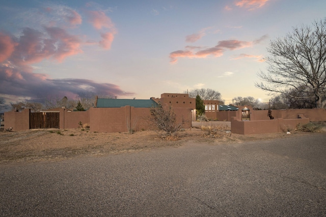 yard at dusk with a fenced front yard and a gate