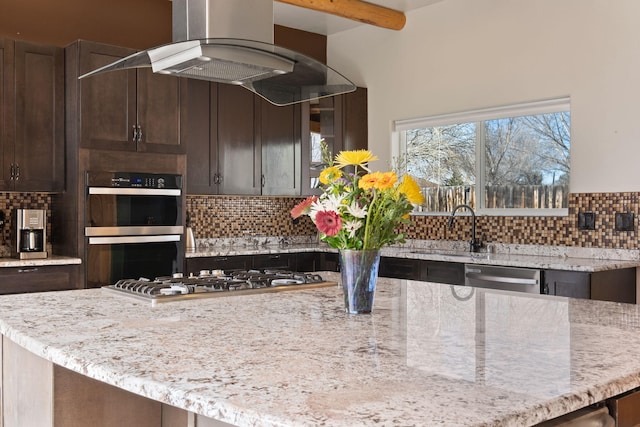 kitchen featuring island exhaust hood, decorative backsplash, stainless steel appliances, and a sink