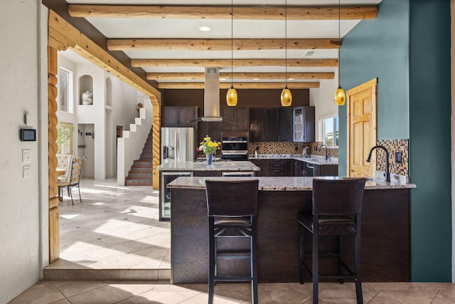 kitchen featuring beverage cooler, backsplash, light stone countertops, beamed ceiling, and island exhaust hood