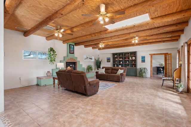 living area with visible vents, beamed ceiling, a glass covered fireplace, and wood ceiling