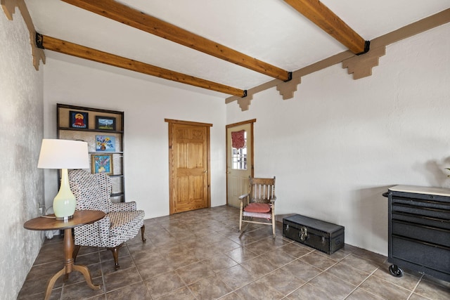 living area featuring beam ceiling and tile patterned floors