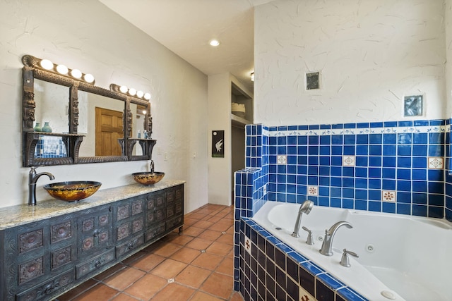 bathroom featuring a whirlpool tub, a textured wall, vanity, and tile patterned floors