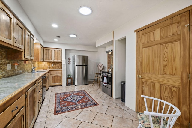 kitchen with light tile patterned floors, tasteful backsplash, appliances with stainless steel finishes, and a sink