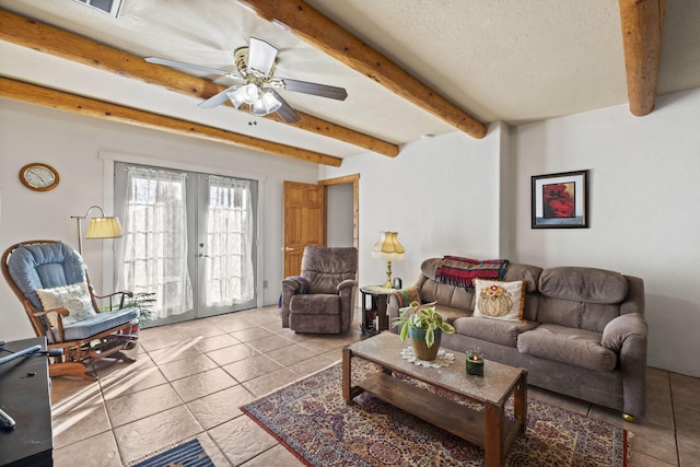 tiled living area featuring a textured ceiling, a ceiling fan, beam ceiling, and french doors