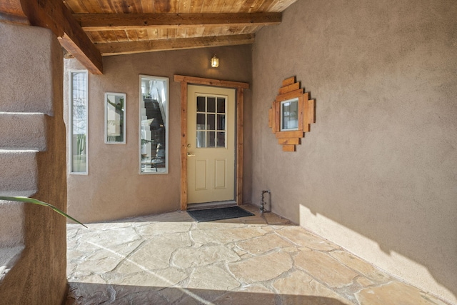 view of exterior entry with a patio and stucco siding