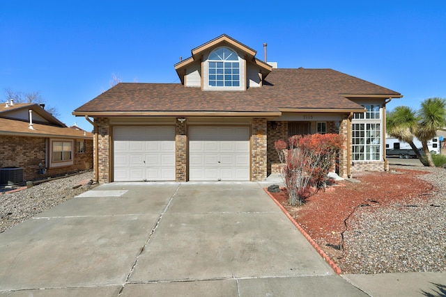 view of front of home with driveway, central AC unit, roof with shingles, an attached garage, and brick siding