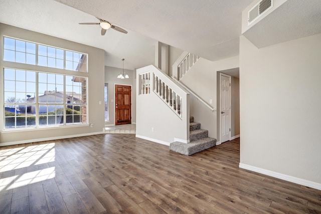 foyer entrance featuring stairs, dark wood-type flooring, plenty of natural light, and visible vents