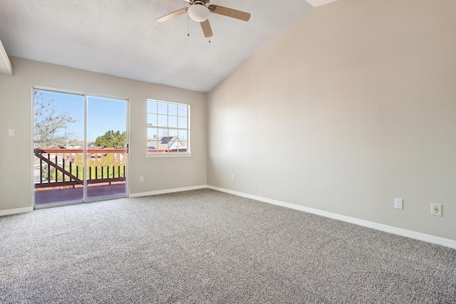 carpeted spare room with lofted ceiling, a textured ceiling, a ceiling fan, and baseboards