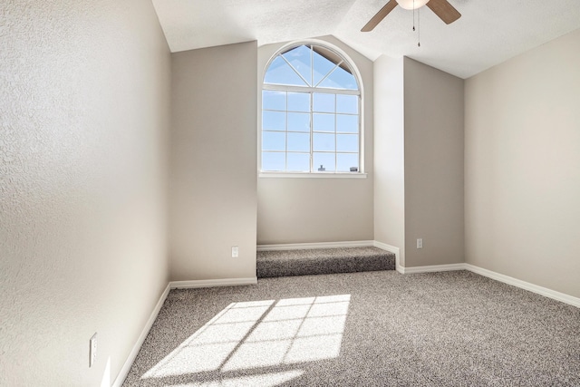 unfurnished room with lofted ceiling, baseboards, and carpet