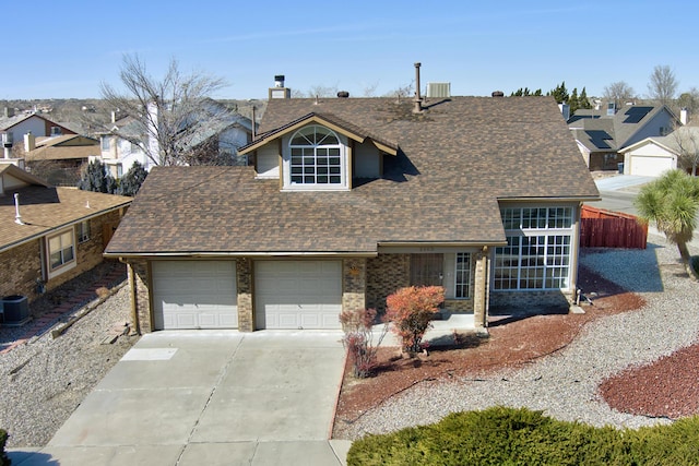 view of front of home featuring driveway, a garage, a chimney, roof with shingles, and central AC