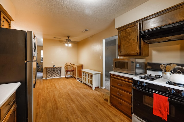 kitchen with stainless steel appliances, light wood finished floors, light countertops, and under cabinet range hood