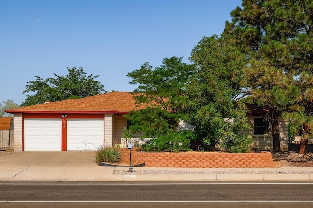 view of front of home featuring a garage, concrete driveway, and brick siding