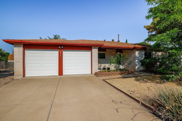 ranch-style home with a garage, concrete driveway, and brick siding