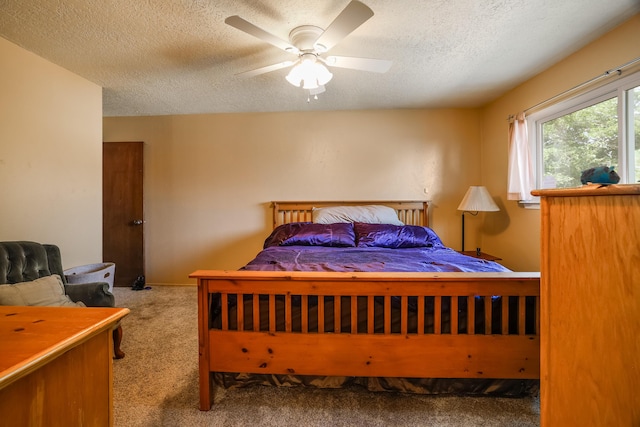 carpeted bedroom featuring a ceiling fan and a textured ceiling