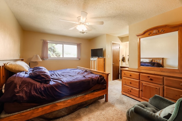 bedroom featuring light carpet, visible vents, a textured ceiling, and a ceiling fan