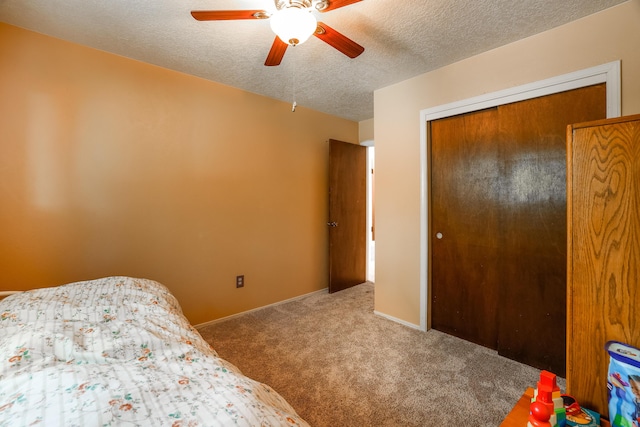 carpeted bedroom with a ceiling fan, a closet, a textured ceiling, and baseboards